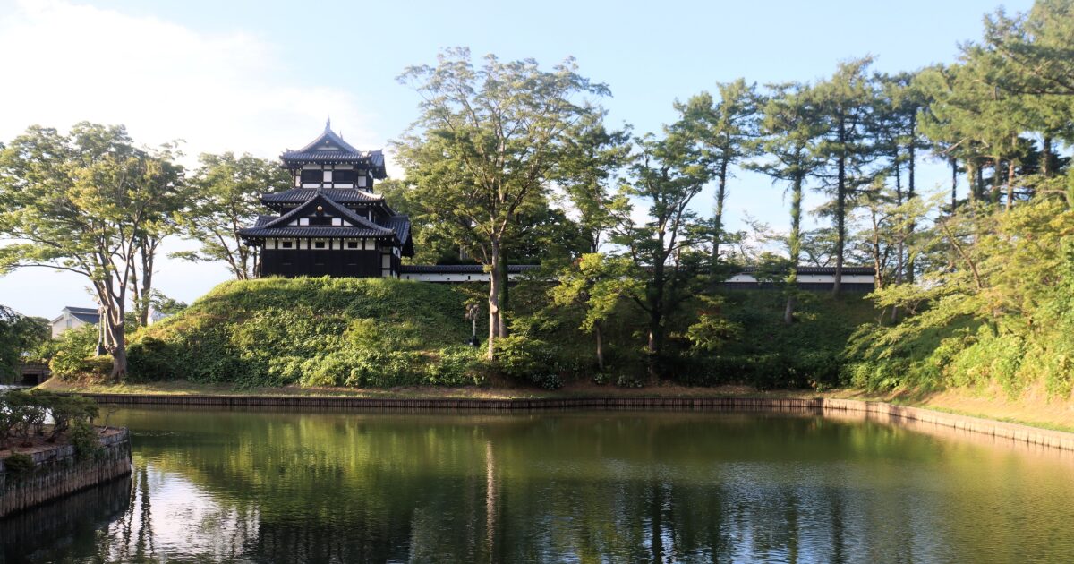 堀に囲まれた高田城と周囲の自然風景