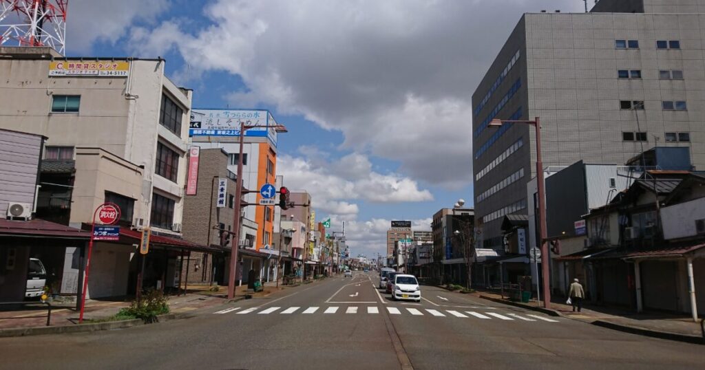雲が広がる中を走る長岡市中心街の道路風景