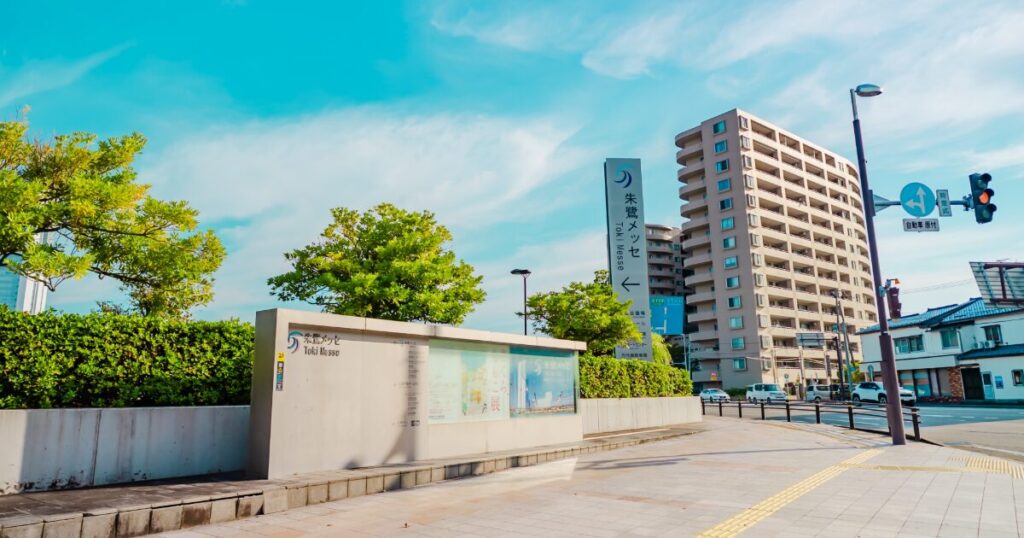 朱鷺メッセの案内看板と青空の街並み
