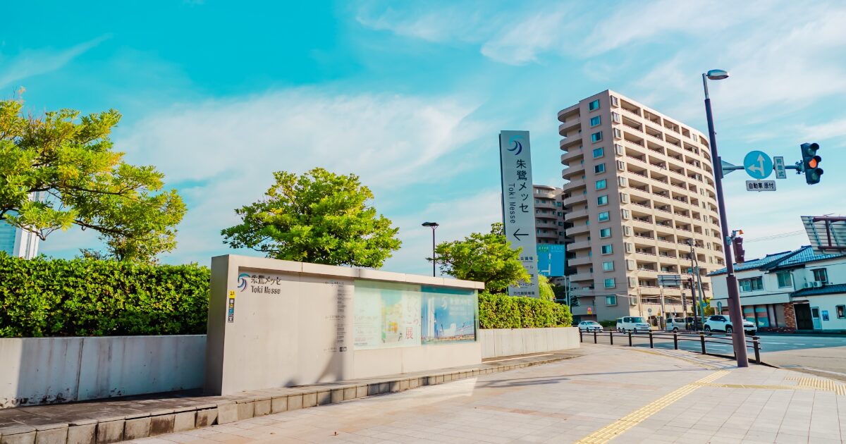 朱鷺メッセの案内看板と青空の街並み