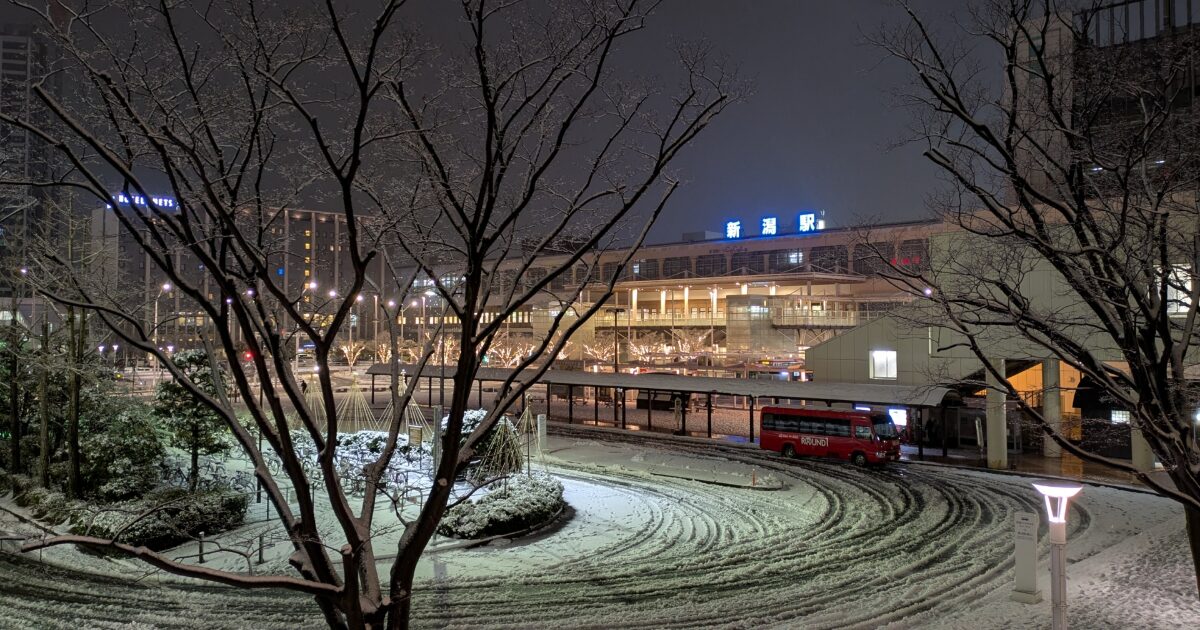 雪の夜にライトアップされた新潟駅とロータリー