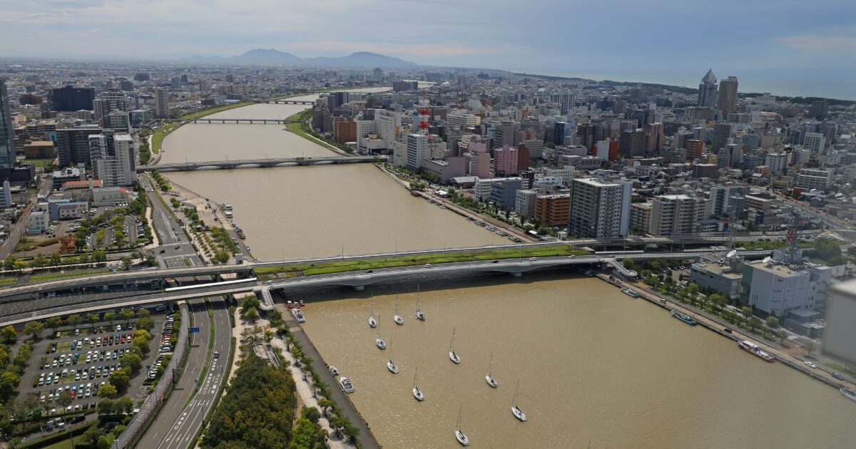 信濃川と新潟市街地の高層ビル群を望む空撮風景