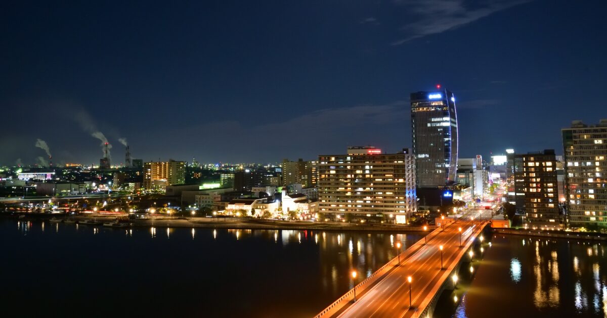 夜景に浮かぶ信濃川と高層ビルが立ち並ぶ新潟市街地