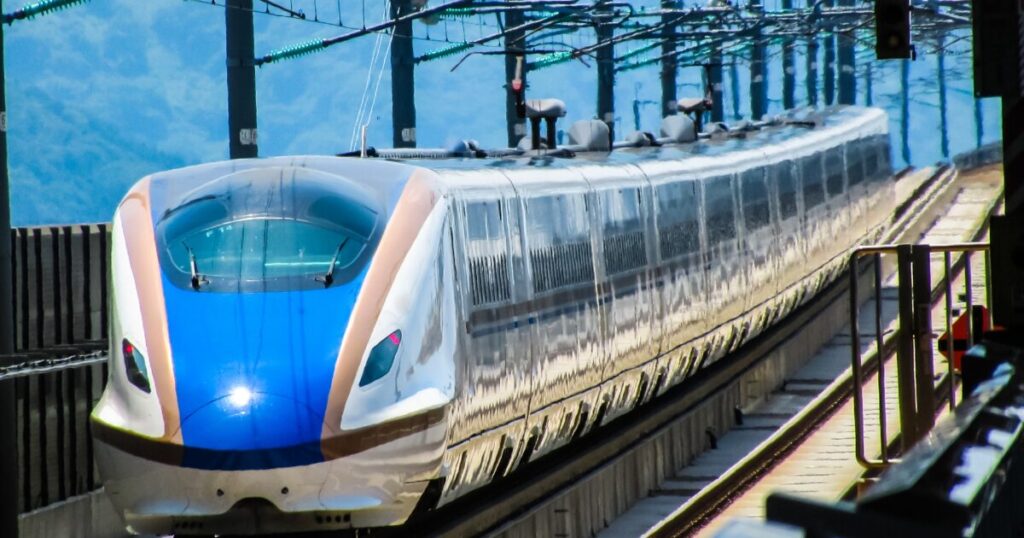 北陸新幹線のE7系車両が走行する駅構内の様子