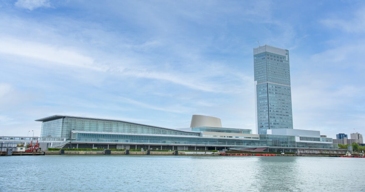 信濃川から見た朱鷺メッセ全景、ガラス張りの建物と高層ホテル