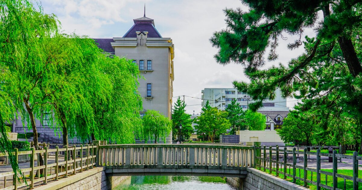 柳の木が並ぶ遊歩道と石橋、歴史ある建物が調和する新潟市歴史博物館周辺