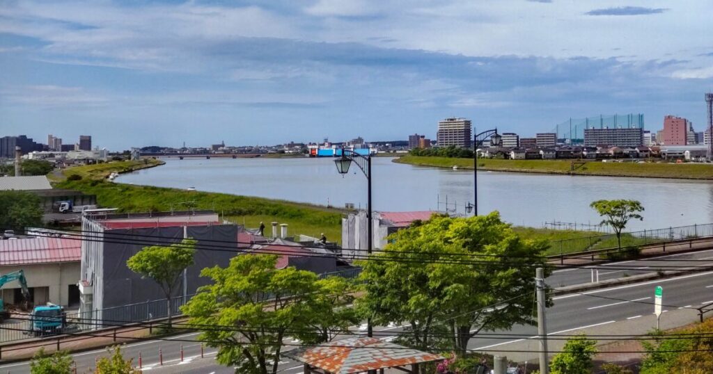 信濃川の河川敷と市街地の遠景、のどかな水辺の風景