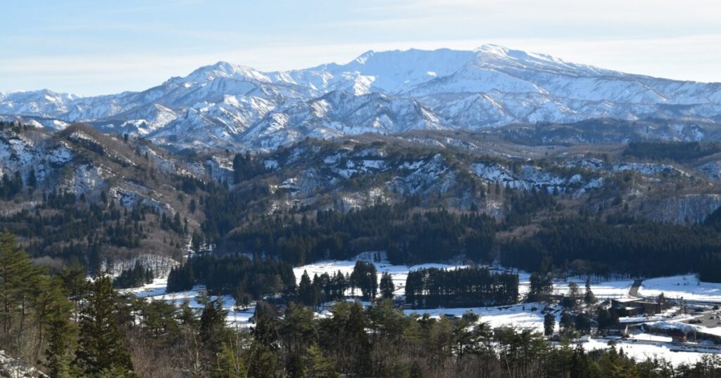 冬の山間部に広がる森林と雪原のパノラマ