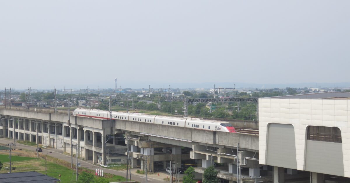 高架を走る新幹線と駅のある郊外の風景