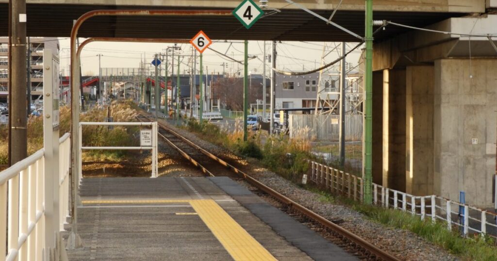 ローカル線の駅ホームと線路と住宅街の景観