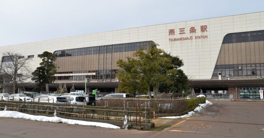 燕三条駅の外観と駅前の駐車場と雪景色