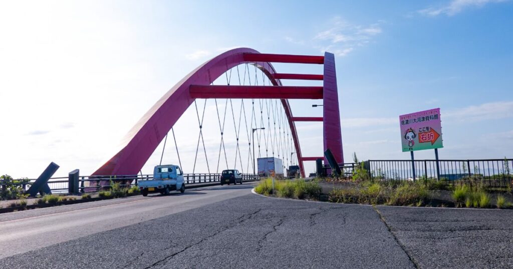 車が走る赤いアーチ橋の道路