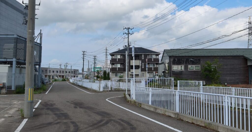 住宅と店舗が立ち並ぶ郊外の道路風景